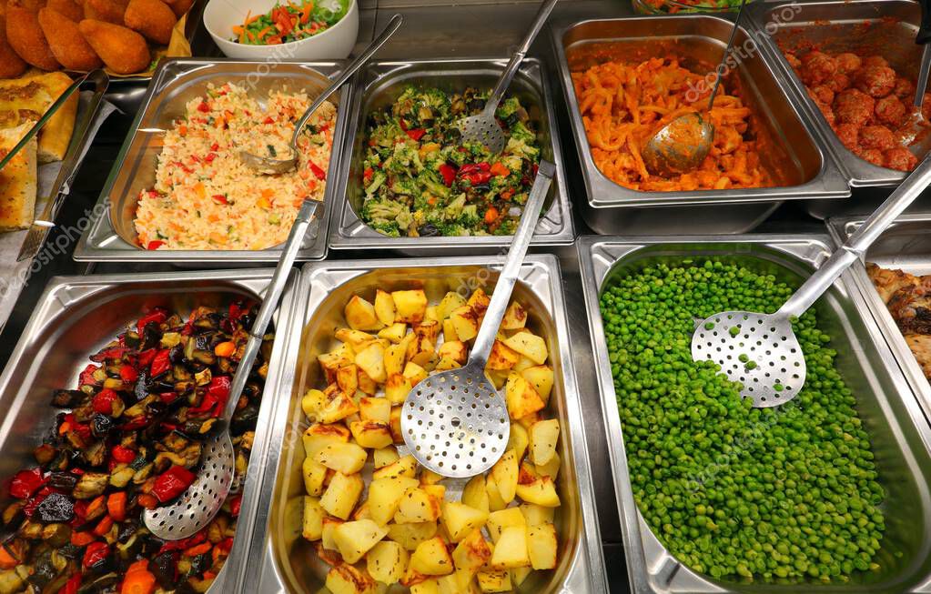 Mensa scolastica con vassoi e piatti colorati.